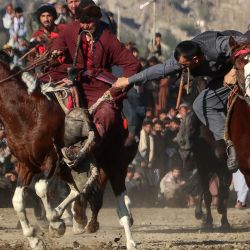 Jinetes afganos compiten en 'Buzkashi' (atrapar cabras), un deporte tradicional de Asia Central, en un campo en el distrito de Fayzabad de la provincia de Badakhshan. | Foto:OMER ABRAR / AFP