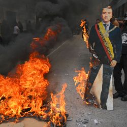 La gente quema una figura de cartón del presidente de Ecuador, Daniel Noboa, durante una protesta contra la extensión de los cortes de energía a 14 horas diarias, la medida más restrictiva tomada por el gobierno para enfrentar la peor sequía en 60 años, en Quito. | Foto:RODRIGO BUENDIA / AFP