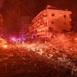 Los equipos de emergencia trabajan en medio del fuego y la destrucción de un edificio en llamas tras un ataque aéreo israelí que tuvo como objetivo la zona industrial en la aldea de Abbasiyeh, en el sur del Líbano, cerca de Tiro, mientras continúa la guerra entre Israel y Hezbolá. | Foto:KAWNAT HAJU / AFP