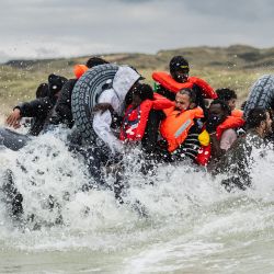 Los migrantes suben a bordo de un bote inflable de un contrabandista en un intento de cruzar el Canal de la Mancha, en la playa de Ecault en Saint-Etienne-au-Mont, cerca de Neufchatel-Hardelot, en el norte de Francia. | Foto:SAMEER Al-DOUMY / AFP