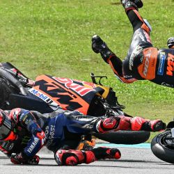 El piloto francés Fabio Quartararo (izq.) de Monster Energy Yamaha MotoGP y el piloto sudafricano Brad Binder (der.) de Red Bull KTM Factory caen tras una colisión durante el Gran Premio de Malasia de MotoGP en el Circuito Internacional de Sepang en Sepang. | Foto:Mohd Rasfan / AFP