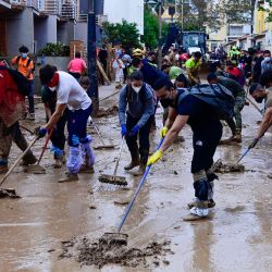 La gente limpia el barro de una calle en Alfafar, en la región de Valencia, este de España, tras las devastadoras inundaciones. El número de muertos por las peores inundaciones de España en una generación ha ascendido a 217, según los rescatadores. | Foto:Jose Jordan / AFP