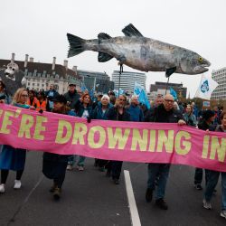 La gente marcha detrás de una pancarta de Extinction Rebellion mientras participa en una "Marcha por el agua limpia" en Londres, pidiendo al gobierno que "detenga el envenenamiento de las aguas de Gran Bretaña". | Foto:BENJAMIN CREMEL / AFP