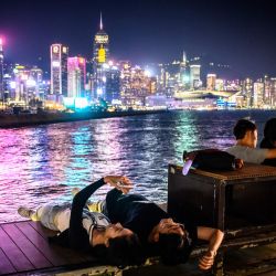 Las parejas disfrutan de las luces nocturnas del horizonte de Hong Kong desde el paseo marítimo de East Coast Park. | Foto:Mladen Antonov / AFP