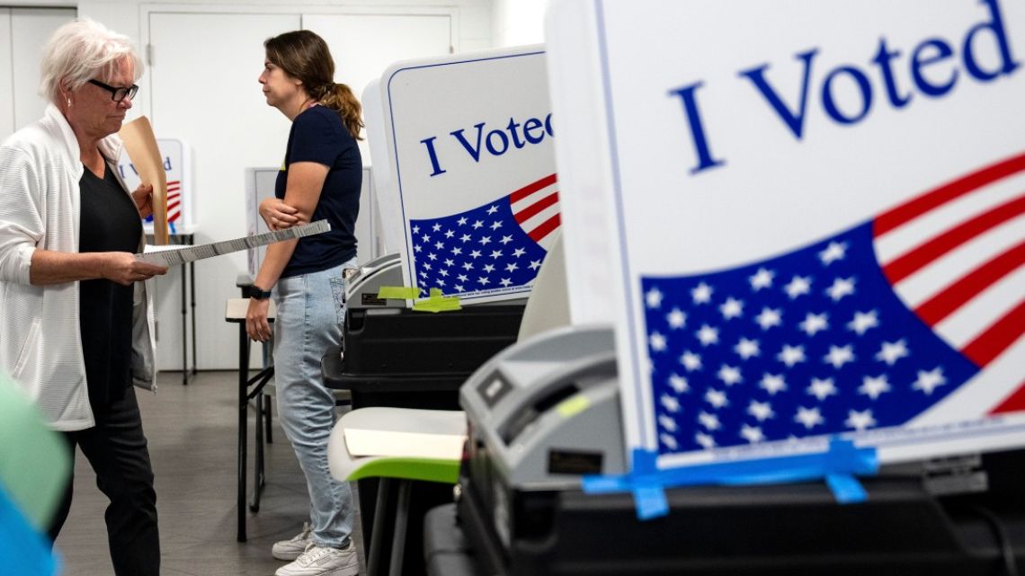 Poll workers assist voters during early voting at a polling location at Longbridge Aquatic Center in Arlington, Virginia