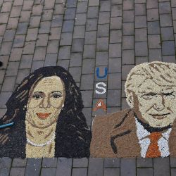 El artista kosovar Alkent Pozhegu trabaja en los toques finales de sus mosaicos de granos y semillas que representan el retrato de la vicepresidenta estadounidense y candidata presidencial demócrata Kamala Harris y el expresidente estadounidense y candidato presidencial republicano Donald Trump en la ciudad de Gjakova. | Foto:ARMEND NIMANI / AFP