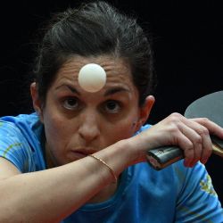 La argentina Ana Codina mira la pelota mientras le sirve a las chinas Xu Jiayi y Zhu Ziyu durante la final de dobles femeninos de tenis de mesa de la Serie Mundial de Tenis de Mesa (WTT) en el Polideportivo Popper & López en Caracas. | Foto:Federico Parra / AFP