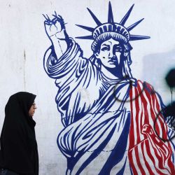 Mujeres iraníes pasan junto a un mural que representa a la Estatua de la Libertad con el brazo que porta la antorcha roto, pintado en las paredes exteriores de la antigua embajada de Estados Unidos, en Teherán, el 6 de noviembre de 2024. Donald Trump ganó las elecciones presidenciales de Estados Unidos, anunciaron los medios estadounidenses, venciendo a la demócrata Kamala Harris para completar una sorprendente remontada política. | Foto:ATTA KENARE / AFP