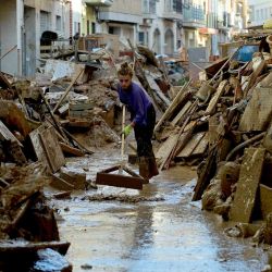 Una mujer limpia el barro entre los escombros en una calle de Paiporta, al sur de Valencia, en el este de España, tras las mortíferas inundaciones. España anunció un paquete de ayuda por valor de 10.600 millones de euros (11.500 millones de dólares) para reconstruir las regiones devastadas por las peores inundaciones en una generación que han matado a 219 personas. | Foto:Jose Jordan / AFP