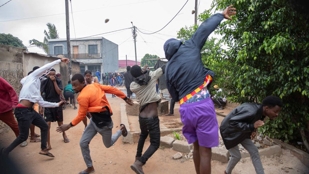 Los manifestantes lanzan piedras mientras se enfrentan a la policía antidisturbios de Mozambique en Maputo. Las tensiones aumentaban en Maputo, cuando la policía lanzó gases lacrimógenos para dispersar a los manifestantes reunidos después de que el principal líder de la oposición llamara a manifestarse por los resultados de las elecciones. | Foto:ALFREDO ZUNIGA / AFP