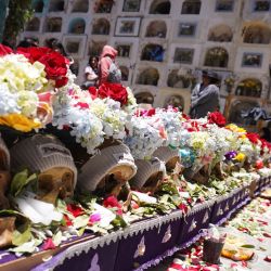 Una mujer coloca ofrendas frente a los cráneos durante la celebración de la festividad de las "Ñatitas", en el Cementerio General, en la ciudad de La Paz, Bolivia. | Foto:Xinhua/Javier Mamani