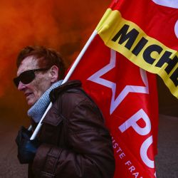 Un empleado de Michelin sostiene una bandera frente a la sede de Michelin durante una manifestación en Clermont-Ferrand, en el centro de Francia. Michelin anunció que la decisión de cerrar las plantas de Cholet y Vannes, en el oeste de Francia, que en conjunto emplean a más de 1.250 personas. | Foto:OLIVIER CHASSIGNOLE / AFP
