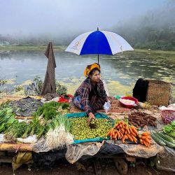 Una vendedora prepara su puesto mientras espera a un cliente en un mercado callejero en Taunggyi, en el estado de Shan, al noreste de Myanmar. | Foto:Sai Aung Main / AFP