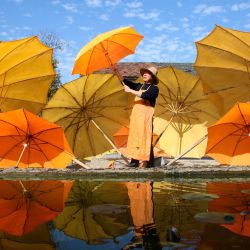 Una trabajadora airea sombrillas de hule, en la aldea Gufeng del distrito de Jingxian, en la provincia de Anhui, en el este de China. | Foto:Xinhua/Cao Li