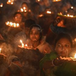 Devotos hindúes con lámparas de aceite de barro y otros materiales religiosos realizan una oración especial 'Mangal Arti' por la paz y la prosperidad en la aldea de Chakla, cerca de Calcuta, India. | Foto:DIBYANGSHU SARKAR / AFP