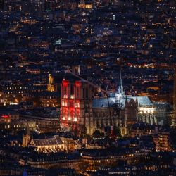 Esta fotografía muestra la catedral de Notre Dame de París iluminada de rojo, en el marco de la "Semana Roja", un evento organizado por la asociación Aide à l'Église en Détresse (AED), para crear conciencia sobre la difícil situación de la población cristiana perseguida por su fe, en París. | Foto:DIMITAR DILKOFF / AFP