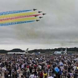 La gente observa al equipo acrobático Bayi de la Fuerza Aérea del Ejército Popular de Liberación (EPL) actuar durante la 15ª Exposición Internacional de Aviación y Aeroespacial de China en Zhuhai, en la provincia de Guangdong, en el sur de China. | Foto:Hector Retamal / AFP