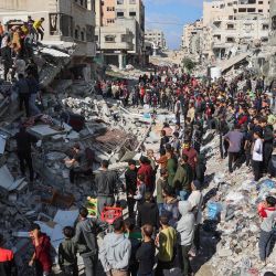 La gente se reúne alrededor de los escombros de una casa destruida en un ataque israelí mientras los rescatistas buscan víctimas en la calle al-Jalaa en el centro de la ciudad de Gaza, en medio de la guerra en curso entre Israel y el grupo militante palestino Hamas. | Foto:OMAR AL-QATTAA / AFP