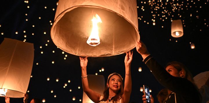 La gente enciende y suelta linternas de papel durante las celebraciones del festival Yi Peng en la ciudad de Chiang Mai, en el norte de Tailandia.