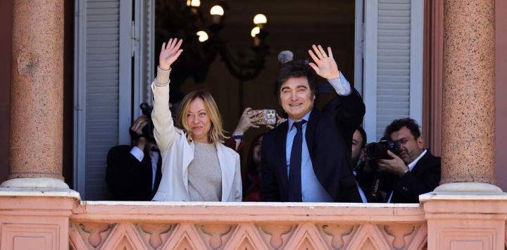 La primera ministra de Italia, Giorgia Meloni, y el presidente de Argentina, Javier Milei, saludan desde el balcón del palacio de gobierno de la Casa Rosada en Buenos Aires.