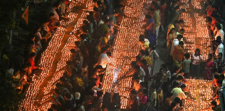 Los devotos encienden lámparas de aceite de barro en un templo para conmemorar 'Kartik Purnima' o el día de luna llena en Hyderabad, India.