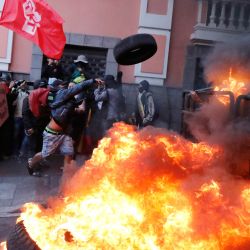 Manifestantes queman neumáticos durante una marcha para conmemorar la histórica masacre de trabajadores de 1922 en Quito, Ecuador. | Foto:Galo Paguay / AFP