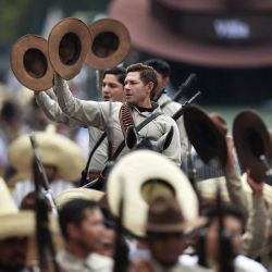 Miembros del ejército mexicano vestidos como soldados revolucionarios participan en el desfile militar conmemorativo del 114 aniversario de la Revolución Mexicana en la Plaza del Zócalo de la Ciudad de México. | Foto:Rodrigo Oropeza / AFP