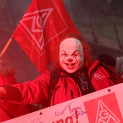 Un participante enmascarado enciende una bengala durante una manifestación de empleados del fabricante de automóviles alemán Volkswagen convocada por el sindicato de trabajadores metalúrgicos IG-Metall en la planta de Volkswagen en Wolfsburg, norte de Alemania, durante una tercera ronda de negociaciones entre la dirección y los representantes de los trabajadores sobre un nuevo acuerdo para la empresa afectada por la crisis. | Foto:RONNY HARTMANN / AFP
