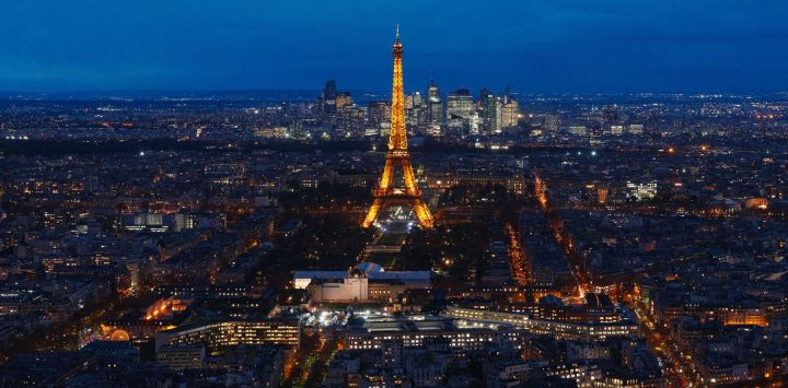 Esta fotografía muestra una vista de la Torre Eiffel y el distrito financiero de La Défense al fondo en París, Francia.