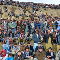 Afganos observan a jinetes compitiendo en 'Buzkashi' (atrapar cabras), un deporte tradicional de Asia Central, en un campo en el distrito de Argo de la provincia de Badakhshan. | Foto:OMER ABRAR / AFP