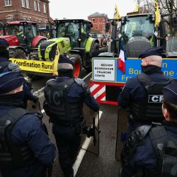 Oficiales del Cuerpo de Seguridad Republicano (CRS) de la policía nacional francesa se colocan delante de tractores mientras agricultores franceses participan en una manifestación organizada por la Coordinación Rural, un sindicato de agricultores, para protestar contra el acuerdo UE-Mercosur, en Estrasburgo, este de Francia. | Foto:Frederick Florin / AFP