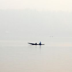 Un hombre rema en su bote en las aguas del lago Dal en medio de la niebla en Srinagar, India. | Foto:TAUSEEF MUSTAFA / AFP
