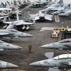 Un oficial de la Marina de los EE. UU. pasa junto a aviones de combate estacionados en la cubierta de vuelo del portaaviones USS Abraham de la clase Nimitz durante una gira de prensa en Port Klang, en las afueras de Kuala Lumpur. | Foto:FAZRY ISMAIL / POOL / AFP