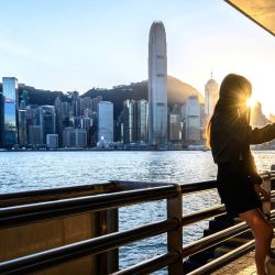 Una mujer se toma una selfie frente al horizonte de Hong Kong. | Foto:Mladen Antonov / AFP