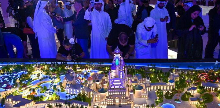 Imagen de invitados tomando fotografías de la maqueta de Tierra de Leyendas Qatar después de la ceremonia de colocación de la primera piedra, en Simaisma, Qatar, marcando el lanzamiento de un proyecto histórico que se convertirá en uno de los parques temáticos más grandes de la región de Medio Oriente y Africa del Norte.