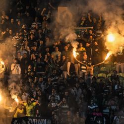 Los seguidores del Sporting de Lisboa encienden bengalas durante el partido de fútbol de la fase de liga de la Liga de Campeones de la UEFA entre el Sporting CP y el Arsenal FC, en el estadio José Alvalade de Lisboa. | Foto:PATRICIA DE MELO MOREIRA / AFP