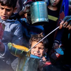 Palestinos desplazados reciben alimentos en un centro de distribución en Deir el-Balah, en el centro de la Franja de Gaza, en medio de la guerra en curso entre Israel y Hamás. | Foto:Bashar Taleb / AFP