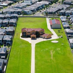 Esta vista aérea muestra una sola propiedad en un gran terreno en medio de una zona densamente desarrollada con muchas casas en Sídney. | Foto:BROOK MITCHELL / AFP