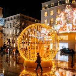 Un peatón camina junto a las luces navideñas en la calle Faubourg-Saint-Honoré, en París, Francia. | Foto:DIMITAR DILKOFF / AFP