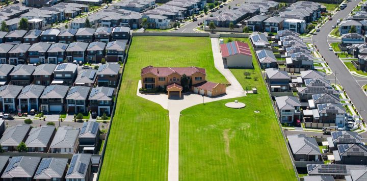 Esta vista aérea muestra una sola propiedad en un gran terreno en medio de una zona densamente desarrollada con muchas casas en Sídney.