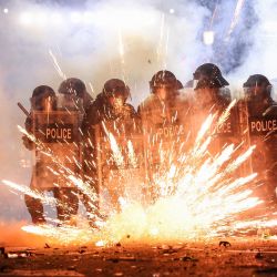 Los fuegos artificiales lanzados por los manifestantes explotan a lo largo de las líneas policiales mientras las dos partes se enfrentan durante una manifestación contra la decisión del gobierno de retrasar las conversaciones sobre la membresía de la Unión Europea en medio de una crisis poselectoral, fuera del Parlamento de Georgia en Tbilisi. | Foto:GIORGI ARJEVANIDZE / AFP