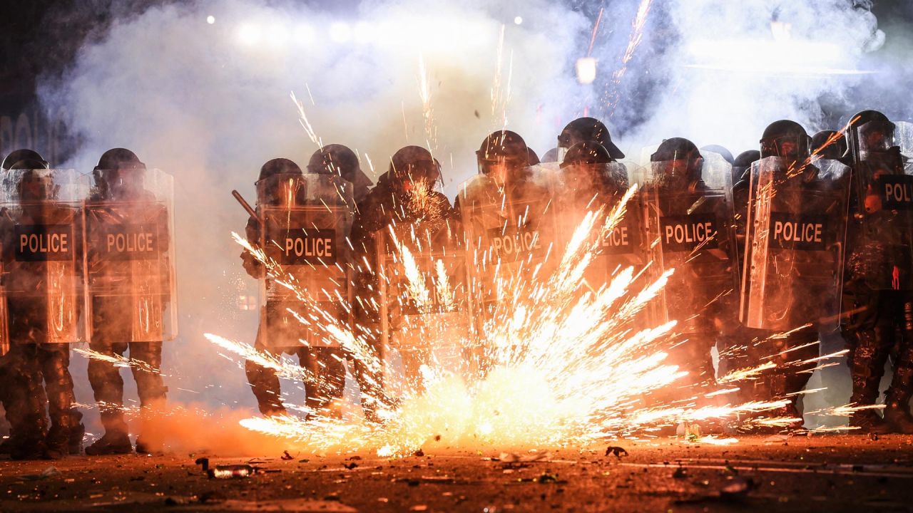 Los fuegos artificiales lanzados por los manifestantes explotan a lo largo de las líneas policiales mientras las dos partes se enfrentan durante una manifestación contra la decisión del gobierno de retrasar las conversaciones sobre la membresía de la Unión Europea en medio de una crisis poselectoral, fuera del Parlamento de Georgia en Tbilisi. | Foto:GIORGI ARJEVANIDZE / AFP