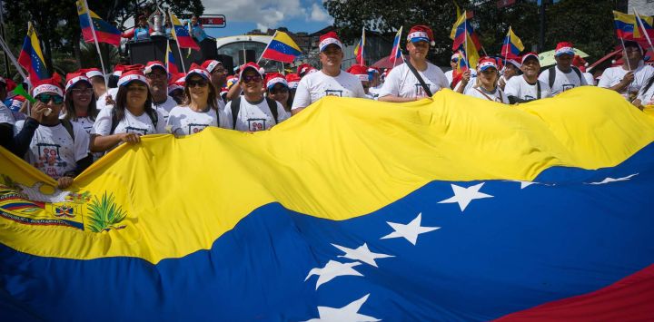 Imagen de personas participando durante una marcha, en Caracas, Venezuela. Cuando falta poco más de un mes para que el presidente venezolano, Nicolás Maduro, sea juramentado para ejercer el periodo 2025-2031, miles de venezolanos tomaron las calles de Caracas bajo la consigna "en defensa de la paz".