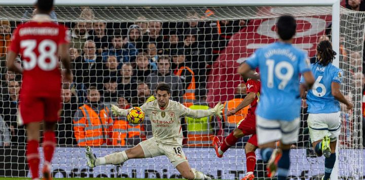 Imagen del arquero Stefan Ortega, de Manchester City, intentando atajar la pelota durante el partido de la Premier League inglesa, entre Liverpool y Manchester City, en Liverpool, Reino Unido.