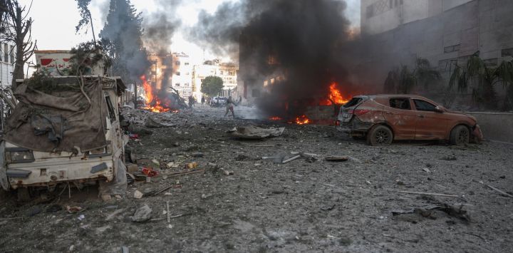 La gente intenta extinguir los incendios tras un ataque aéreo que tuvo como objetivo la ciudad de Idlib, en el norte de Siria, controlada por los rebeldes.