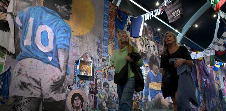 Mujeres recorren la exposición "Diego Eterno", un recorrido inmersivo por la vida del astro del fútbol argentino Diego Maradona, en La Rural de Buenos Aires.