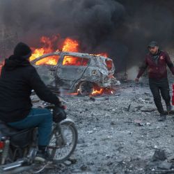 La gente intenta extinguir los incendios tras un ataque aéreo que tuvo como objetivo la ciudad de Idlib, en el norte de Siria, controlada por los rebeldes. | Foto:OMAR HAJ KADOUR / AFP