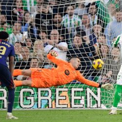 El centrocampista argentino del Real Betis, Giovani Lo Celso, marca el primer gol de su equipo desde el punto de penal durante el partido de fútbol de la liga española entre el Real Betis y el FC Barcelona en el estadio Benito Villamarín en Sevilla. | Foto:CRISTINA QUICLER / AFP