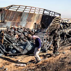 Los sirios buscan piezas de metal y municiones sin explotar en el lugar del ataque aéreo israelí de la noche anterior que tuvo como objetivo cargamentos de armas que pertenecían a las fuerzas del gobierno sirio en Qamishli, en el noreste de Siria, de mayoría kurda. | Foto:DELIL SOULEIMAN / AFP
