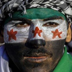 Un hombre lleva la cara pintada con la bandera de la oposición mientras miembros de la comunidad siria y sus partidarios se reúnen para celebrar la caída del presidente sirio Bashar al-Assad ante una ofensiva de los rebeldes liderados por islamistas, en el distrito Fatih de Estambul. | Foto:KEMAL ASLAN / AFP